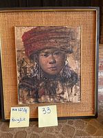 Photo showing framed vintage portrait artwork of a man with a red turban, close-up of painting and frame.