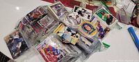 Mixed lot of more than 100 baseball and hockey cards in various protective sleeves and loose stacks, featuring multiple players.