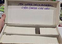 Open cardboard box showing stacks of white-backed baseball cards arranged in three columns with handwriting on the lid that reads '1992 UPPER DECK BASEBALL 1,400 CARDS LIKE NEW'.