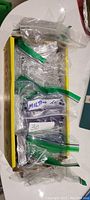 Box containing multiple clear zip-lock baggies filled with loose basketball trading cards, some labeled with numbers and notes.