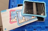 HaoKids E10 Android 10.0 Kids Tablet with blue protective case shown alongside its original box and user manuals