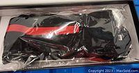 Pair of black and red rechargeable heated socks in plastic packaging