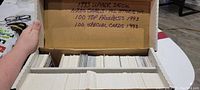 Open box containing neatly organized stacks of hockey cards in protective sleeves, with handwritten label on box lid detailing content as 1993 Upper Deck 1200 hockey cards including All Stars, 100 Top Prospects, and 100 Special Cards.