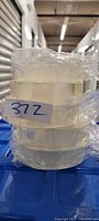 Stack of five clear rolls of nanoparticle double sided tape, each individually wrapped in clear plastic film.