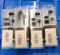 Photo showing four sealed packages of black wired earbuds with extra ear tips included. Each package has a barcode label and shows earbuds inside clear plastic display packaging.