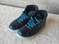 Pair of Air Jordan sneakers showing front and left side angles with teal shoelaces and black leather upper