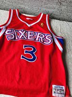 Front upper portion of red Philadelphia 76ers jersey showing Sixers logo, NBA patch, number 3, and Hardwood Classics patch on lower left.