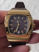 Front view of square gold-tone Lucien Picard men's wristwatch showing brown dial with gold hour markers and date display at 6 o'clock.