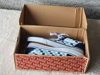 Vans Old Skool men's sneakers in blue and white checkerboard pattern inside original Vans box.