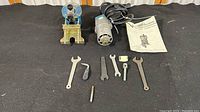 Complete set displaying Ryobi power unit, manual, and assorted hand tools on a black surface
