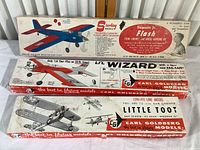 Three kit boxes stacked: Sterling Models Roughrider Jr. Flash, Carl Goldberg Lil Wizard, and Carl Goldberg Little Toot