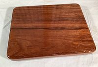 Top view of the rectangular wooden serving board showing glossy wood grain finish and smooth edges.