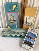 Four vintage wooden model kits including three ship models and one fishing dock kit in various worn boxes with instructions.