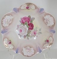 Front view of the vintage hand painted porcelain bowl showing the rose floral design and scalloped edges with color gradients.