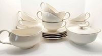 Set arranged with 8 cups stacked on 8 saucers, creamer and sugar bowl at front.