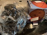 Two cake pans shown, one wrapped in plastic and one in original Wilton Sports Ball Pan box.