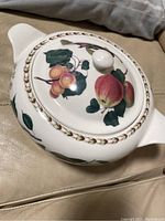 Top and side view of the fine china serving bowl with lid, showing colorful fruit patterns and gilt braided border.