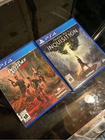 Two Sony PlayStation 4 game cases, Jagged Alliance Rage and Dragon Age Inquisition.