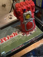 Photo of the Risk board game box and the Marvel Infinity Gauntlet toy together on a table.