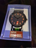 Photo of a brand new Super Mario Bros wristwatch in original packaging box showing the watch face with Mario character and star hour markers.
