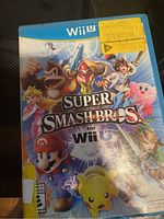 Front view of the Super Smash Bros for Wii U game case showing character artwork and condition.