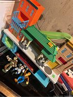 Vintage TMNT figures along with a newer multi-sectional playset featuring buildings, slide, pool, and various colors and details.