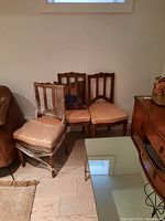 Four Louis Philippe period wooden chairs, two shown side by side with peach upholstery, one wrapped in protective plastic, visible minor wear and scratches