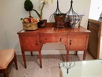 Front view of sideboard showing marquetry pattern, two doors, central drawer