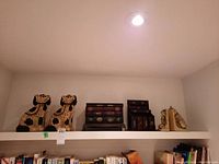 Overview photo of the full lot with both ceramic dog figures, wooden book style box, pen holder, and pair of bookends on a white shelf.