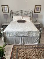 Full front view of assembled bed with mattress and bedding showing headboard, footboard and overall design