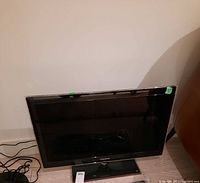 Samsung 32-inch flat screen TV showing full front view with gloss bezel and stand base.