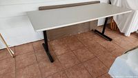 White formica top fixed banquet table viewed from front side showing overall condition and design