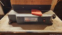 4 1/8 inch Craftsman jointer-planer on work surface with orange plastic guard.