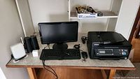 Overview of Epson printer, Dell keyboard, mouse, monitor, speakers, and network equipment on a desk.