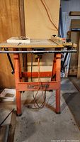 Full view of the router table showing metal frame, wood top, and mounted router underneath.