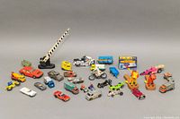 Full lot packed with vintage diecast cars, trucks, motorcycles, and toys arranged on a neutral background.
