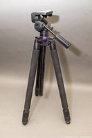 Full view of the black Velbon Neo Carmagne 630 tripod standing upright showing its three extendable legs and top mounting plate with pan handle.