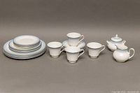 Complete set of all items laid out including plates, teacups, saucers, creamer, and sugar bowl.