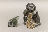 Two soapstone carvings including larger signed figure and smaller greenish carved piece