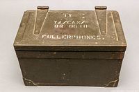 Closed metal telegraph box in olive drab with military stenciled markings.