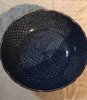 Top view of a blue Japanese serving bowl showing intricate spiral patterning with various geometric textures inside the bowl.