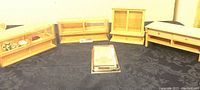 Four unfinished dollhouse size counter top furniture pieces set on a dark cloth.
