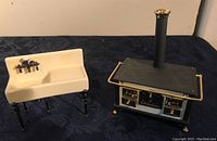 Two-piece dollhouse kitchen set with a white sink and old-fashioned stove on display
