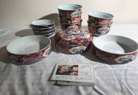 Complete set of Japanese porcelain bowls and plates arranged in groups showing the floral design and included items alongside a product information card.
