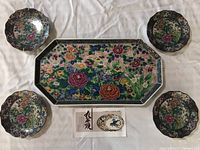Top-down view of the full set: one rectangular tray and four matching saucer plates arranged around it.