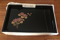Full view of black lacquer coffee tray with floral design and Mokusei Shikki label.