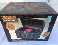 Box showing the product packaging with image and text about Pirates of the Caribbean CD Boombox and glowing pirate heart feature.