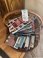 Photo of a wicker basket filled with various books and magazines, showing a view from above.