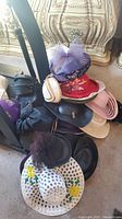 Assorted hats displayed on a hat stand including straw, satin, velour styles