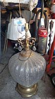 Full view of glass and brass table lamp with harp and crystal pendants.